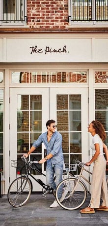 The Pinch Charleston entrance with couple and bikes – boutique hotel featured in digital marketing campaign by Easygridon Marketing